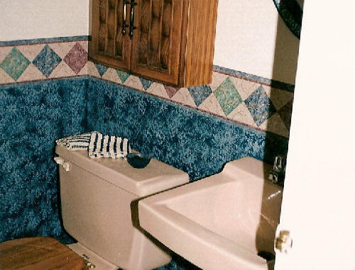 Removed wall paper trim and painted neutral Behr nude to blend with beige toilet and sink, replaced mirror, light and sink fixtures and matching accessories